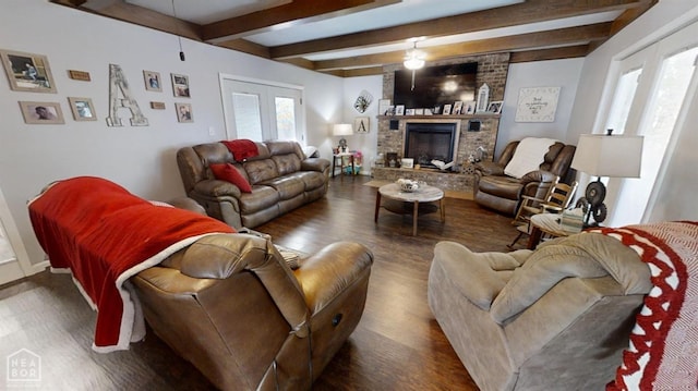 living area featuring ceiling fan, a fireplace, wood finished floors, french doors, and beam ceiling