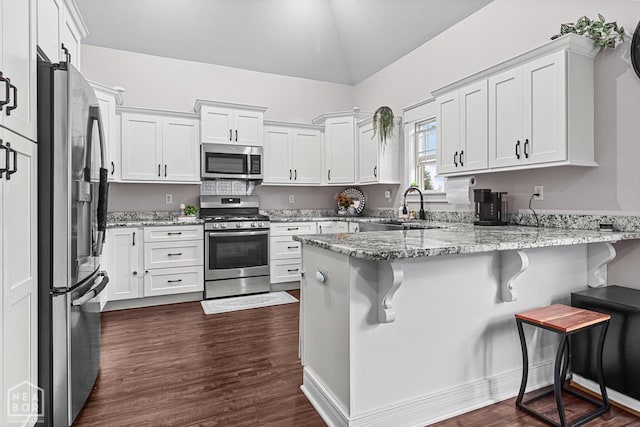 5301 Bridger Park Ct, Jonesboro, AR 72405 - kitchen featuring stainless steel appliances, a peninsula, lofted ceiling, white cabinets, and light stone counters