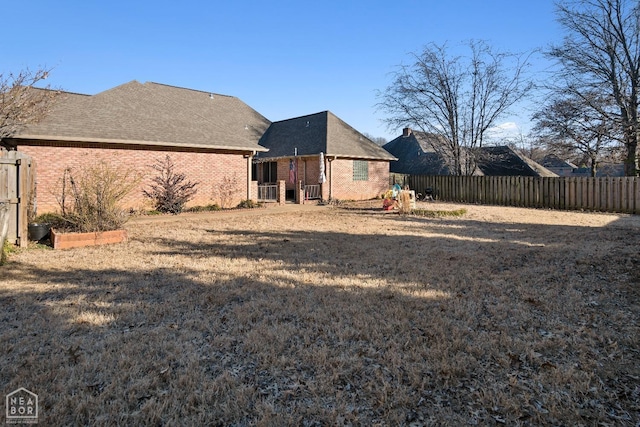 exterior space featuring brick siding and fence