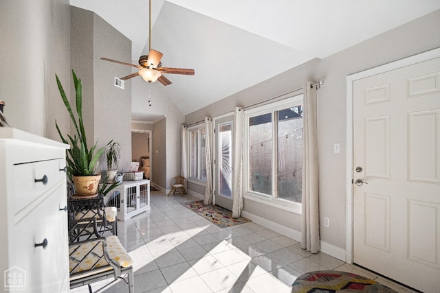 interior space featuring baseboards, vaulted ceiling, light tile patterned floors, a ceiling fan, and visible vents