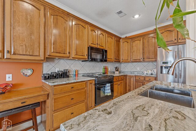 kitchen featuring black appliances, light stone countertops, visible vents, brown cabinets, and a sink