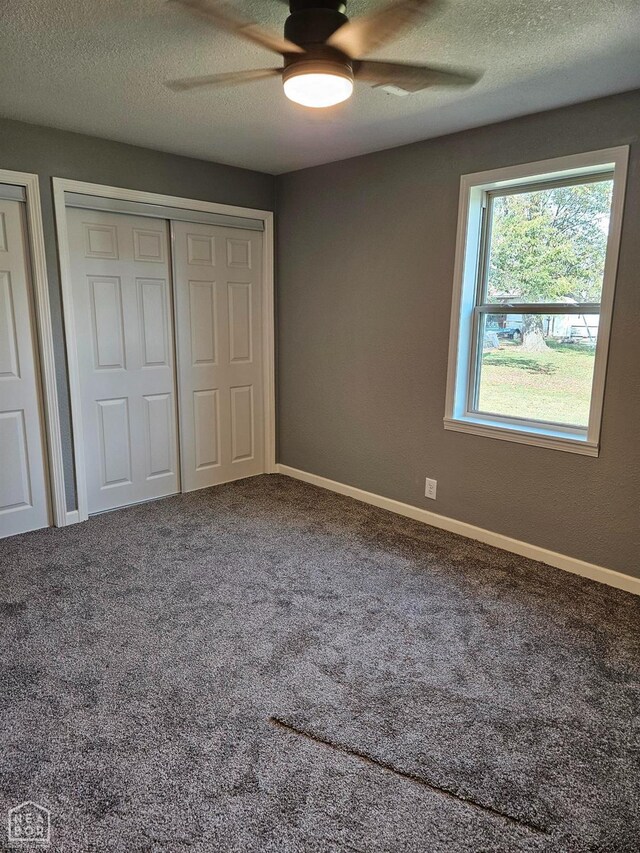unfurnished bedroom with baseboards, a textured ceiling, a ceiling fan, and carpet floors