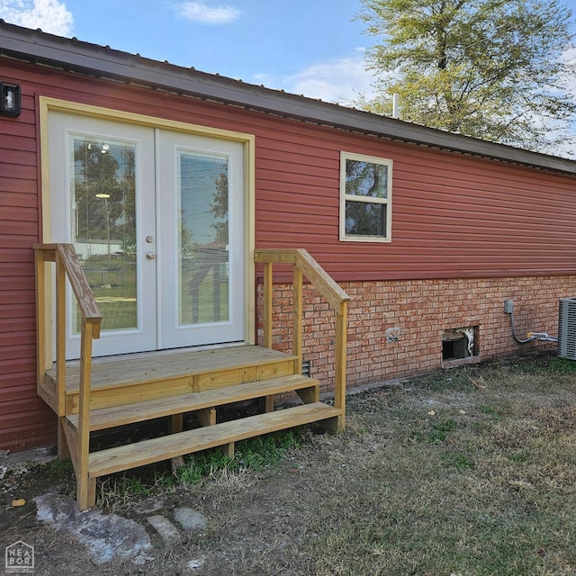 doorway to property featuring brick siding and french doors