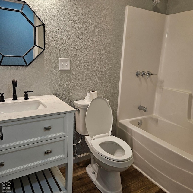 full bath featuring a textured wall, shower / bathing tub combination, toilet, and wood finished floors