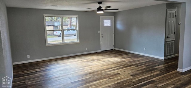 foyer featuring dark wood-type flooring, visible vents, baseboards, and ceiling fan