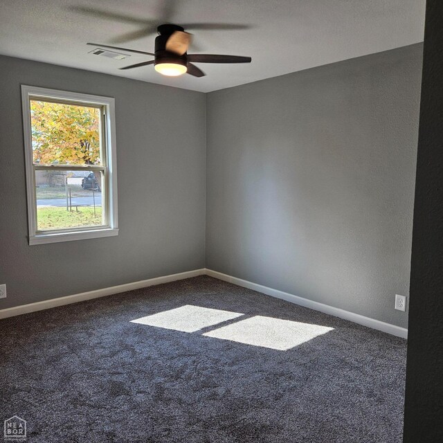 spare room featuring carpet floors, ceiling fan, visible vents, and baseboards