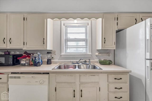 kitchen with a sink, white cabinetry, white appliances, and light countertops