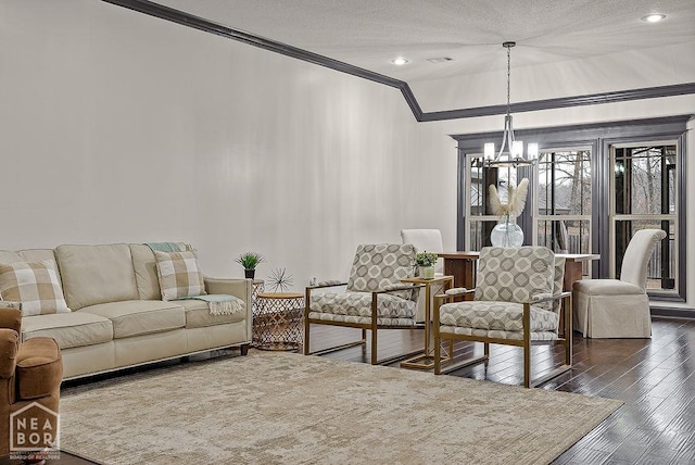 5200 Julia Cv, Jonesboro, AR 72404 - living room featuring dark wood-style floors, a textured ceiling, an inviting chandelier, and ornamental molding