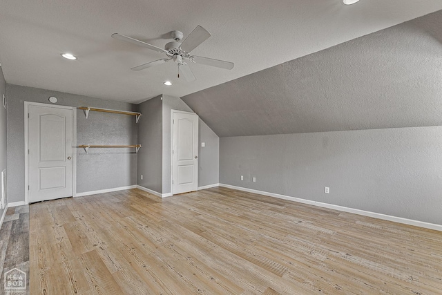 bonus room featuring baseboards, ceiling fan, light wood-type flooring, a textured ceiling, and vaulted ceiling