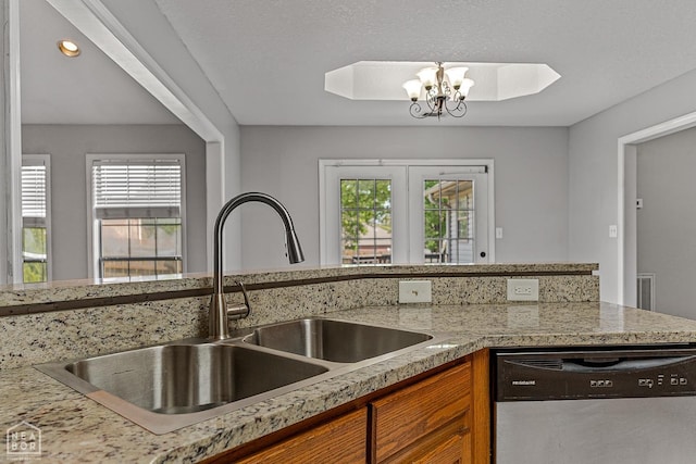 kitchen featuring a sink, a chandelier, dishwasher, and brown cabinets