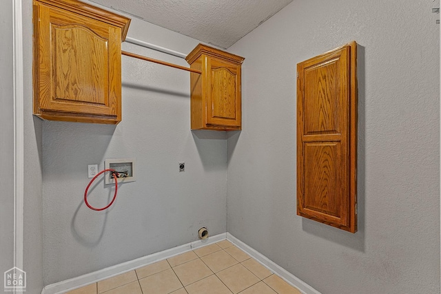 clothes washing area with baseboards, electric dryer hookup, light tile patterned flooring, hookup for a washing machine, and cabinet space
