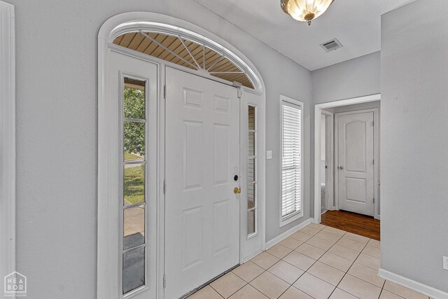 foyer with visible vents, baseboards, and light tile patterned flooring