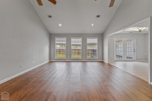 spare room with visible vents, baseboards, wood finished floors, and ceiling fan with notable chandelier