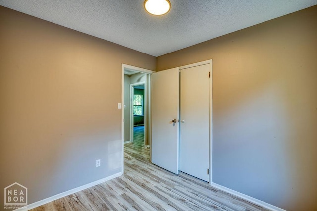 1610 Smoot Dr, Jonesboro, AR 72401 - unfurnished bedroom with light wood-style floors, a closet, and a textured ceiling