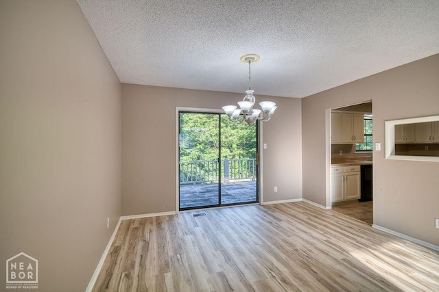 1610 Smoot Dr, Jonesboro, AR 72401 - unfurnished room featuring a chandelier, light wood finished floors, and a textured ceiling