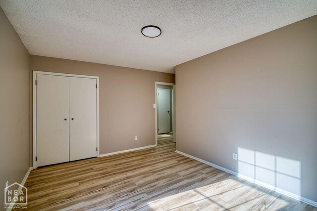 1610 Smoot Dr, Jonesboro, AR 72401 - unfurnished bedroom featuring light wood-type flooring, a textured ceiling, and a closet
