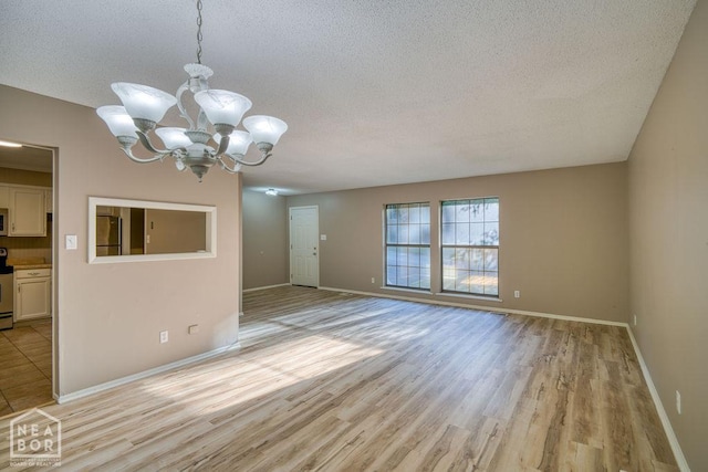 1610 Smoot Dr, Jonesboro, AR 72401 - unfurnished dining area featuring a chandelier, a textured ceiling, and light wood-type flooring