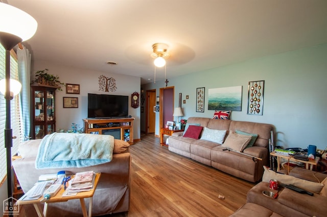 living room with wood finished floors and a ceiling fan