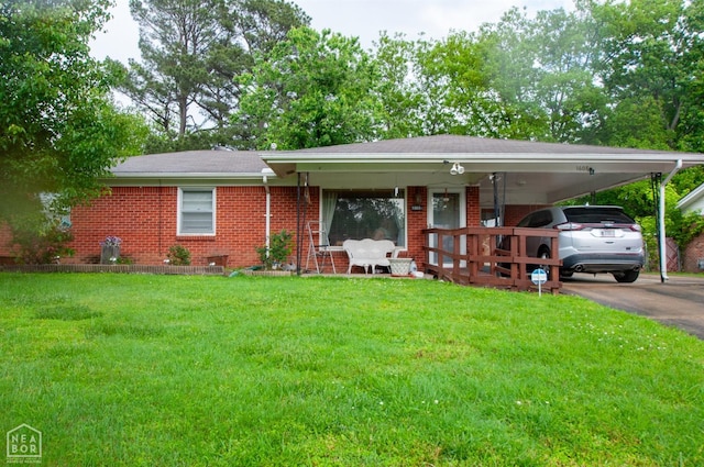 single story home with brick siding, a front yard, an attached carport, and asphalt driveway