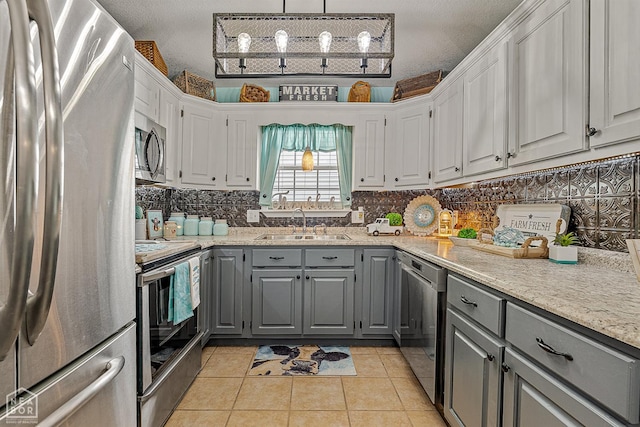 2708 N 5th St, Paragould, AR 72450 - kitchen featuring stainless steel appliances, gray cabinetry, decorative backsplash, and white cabinetry