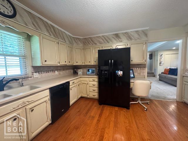 700 11th St, Corning, AR 72422 - kitchen featuring black appliances, a textured ceiling, light countertops, wood finished floors, and tasteful backsplash