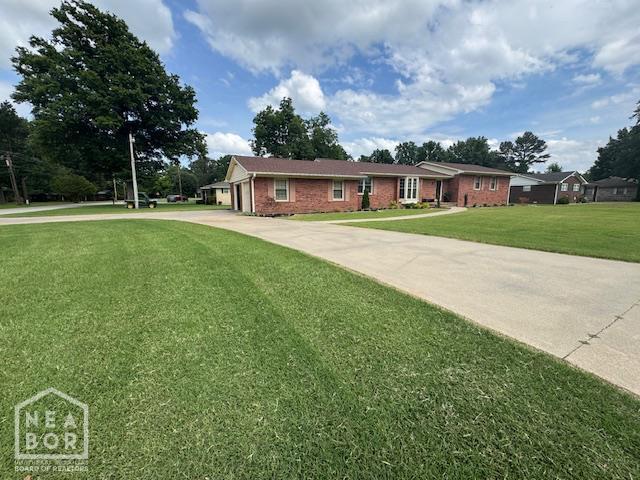 700 11th St, Corning, AR 72422 - ranch-style house with driveway, a front lawn, an attached garage, and brick siding