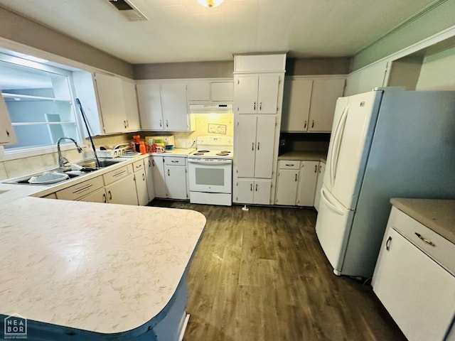 509 NE 4thw, Walnut Ridge, AR 72476 - kitchen featuring white appliances, dark wood finished floors, light countertops, under cabinet range hood, and a peninsula