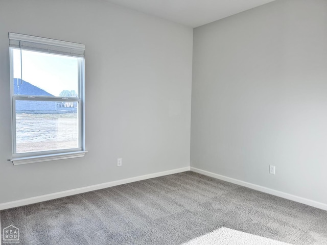 unfurnished room with carpet flooring and baseboards