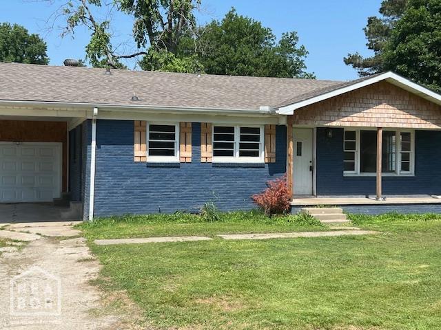 304 S 11th Ave S, Paragould, AR 72450 - single story home with a porch, a front yard, driveway, brick siding, and an attached garage