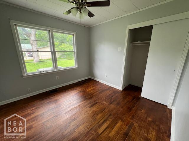 304 S 11th Ave S, Paragould, AR 72450 - unfurnished bedroom featuring ornamental molding, dark wood-type flooring, a closet, and ceiling fan