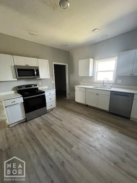kitchen with light countertops, white cabinetry, a sink, and appliances with stainless steel finishes