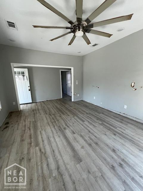 unfurnished room with wood finished floors, ceiling fan, and visible vents