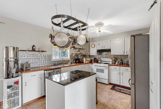 154 Mockingbird Cir, Marmaduke, AR 72443 - kitchen with white cabinetry, under cabinet range hood, a sink, stainless steel appliances, and backsplash