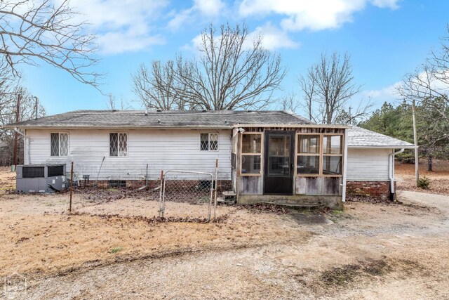 154 Mockingbird Cir, Marmaduke, AR 72443 - back of property featuring central air condition unit, a sunroom, and a shingled roof