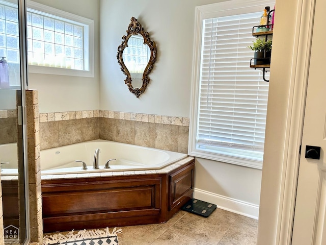 full bath with baseboards, tile patterned floors, and a bath