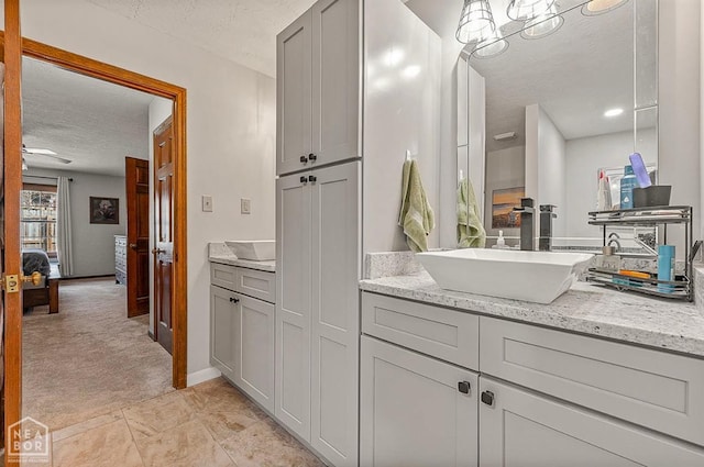 700 Oak Hollow Ln, Jonesboro, AR 72401 - bathroom featuring a textured ceiling, vanity, connected bathroom, baseboards, and a ceiling fan