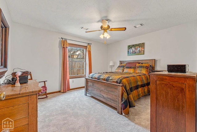 bedroom with ceiling fan, light carpet, visible vents, and baseboards