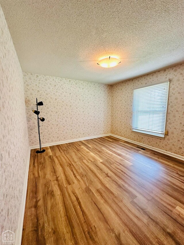 320 Church, Weiner, AR 72479 - empty room featuring a textured ceiling and wood finished floors