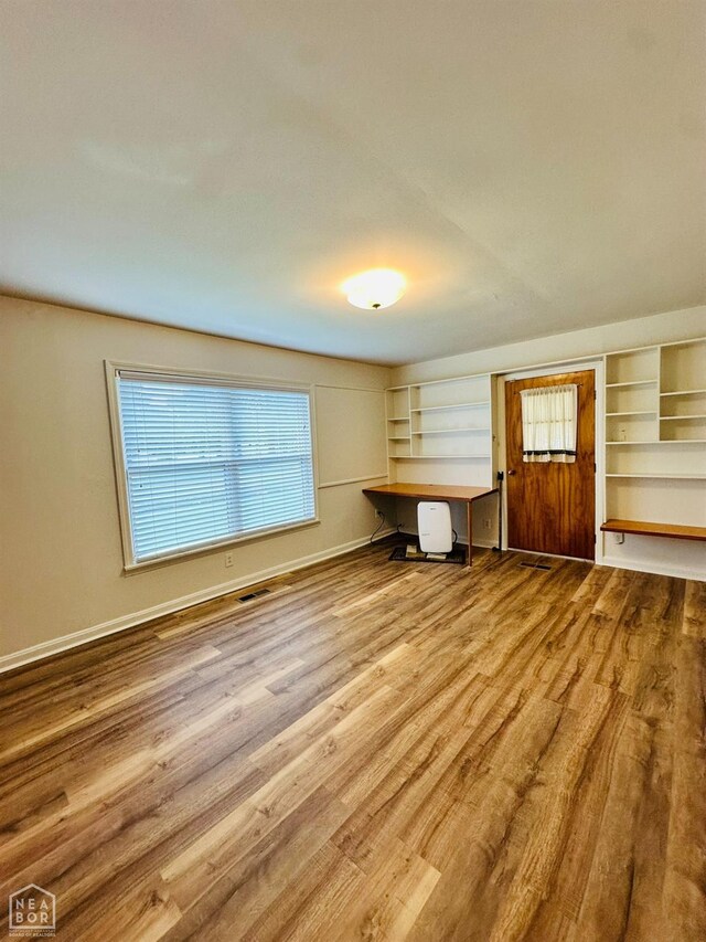 320 Church, Weiner, AR 72479 - unfurnished living room with baseboards, visible vents, a healthy amount of sunlight, and wood finished floors