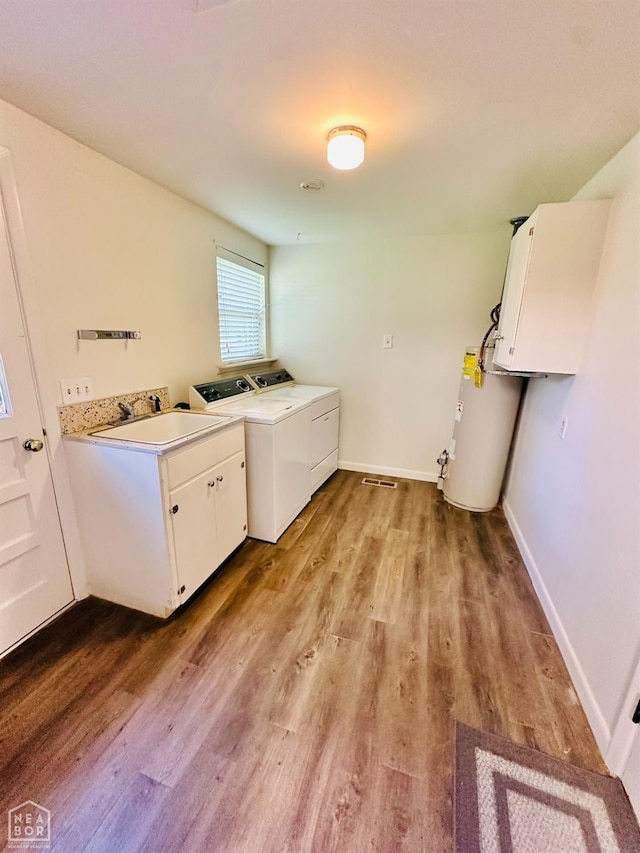 320 Church, Weiner, AR 72479 - washroom with light wood-style floors, cabinet space, a sink, water heater, and washer and clothes dryer