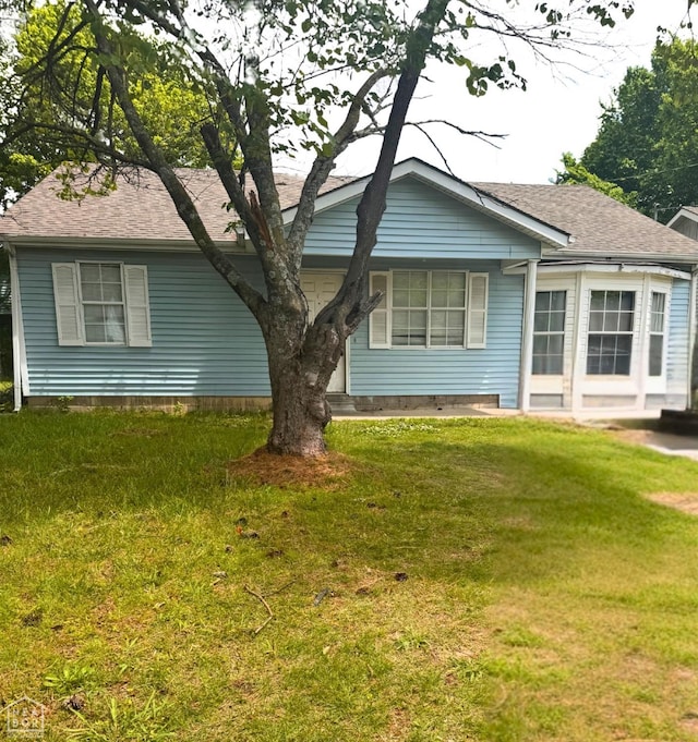 back of property with a lawn and roof with shingles