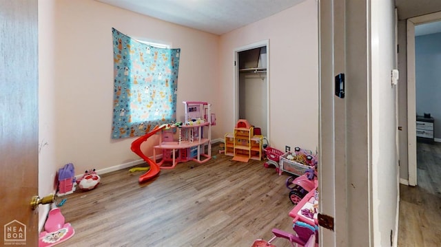 rec room with baseboards and wood finished floors
