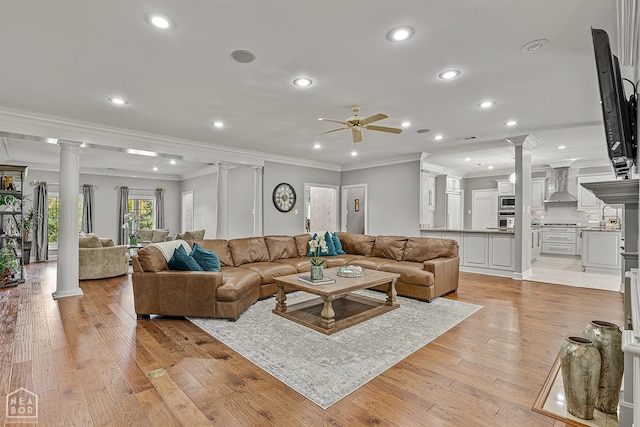 living area featuring decorative columns, ceiling fan, ornamental molding, recessed lighting, and light wood-style flooring