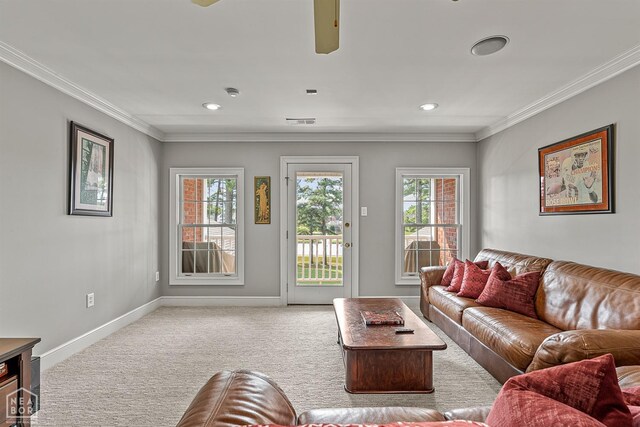 living area with carpet flooring, baseboards, crown molding, plenty of natural light, and ceiling fan