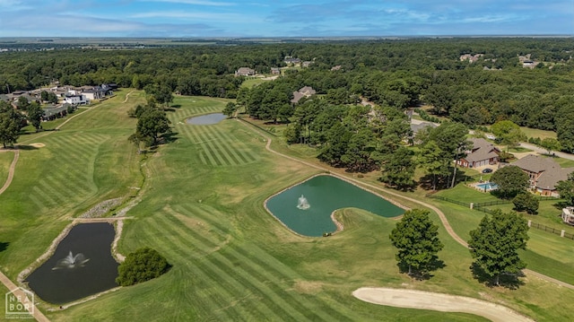 aerial view of property's location featuring a large body of water, a forest, and a local golf course