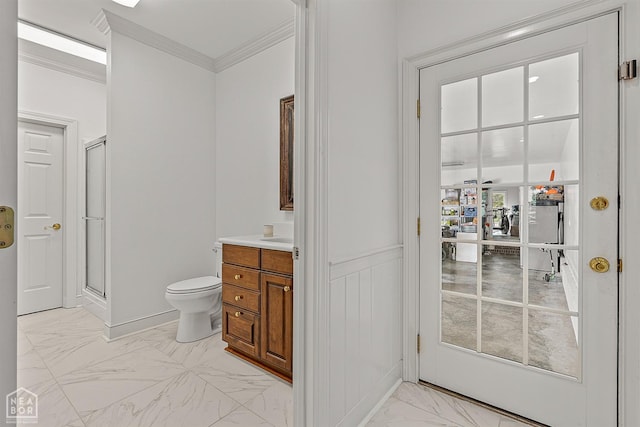 bathroom featuring marble finish floors, a stall shower, toilet, crown molding, and vanity