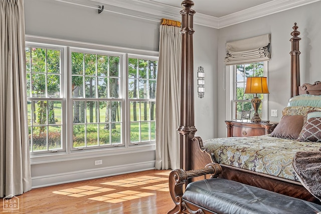 bedroom with ornamental molding, light wood-type flooring, and baseboards