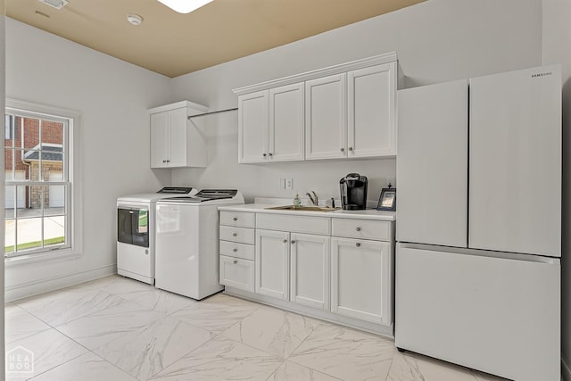 laundry room featuring independent washer and dryer, light marble finish floors, and healthy amount of natural light