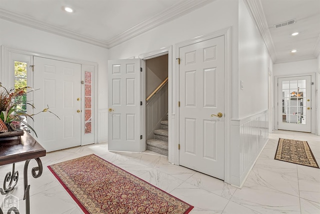 entryway featuring ornamental molding, light marble finish floors, wainscoting, stairway, and recessed lighting