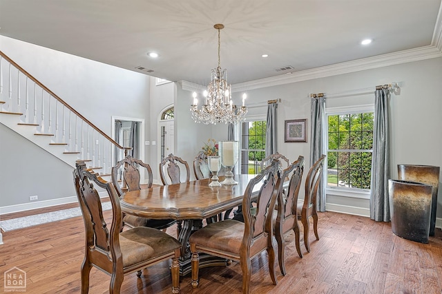 dining space featuring a chandelier, light wood-style flooring, crown molding, baseboards, and recessed lighting
